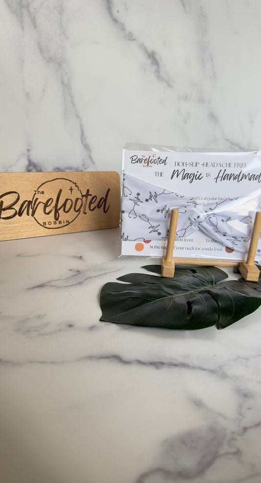 a white headband featuring black stethoscopes all around it. 