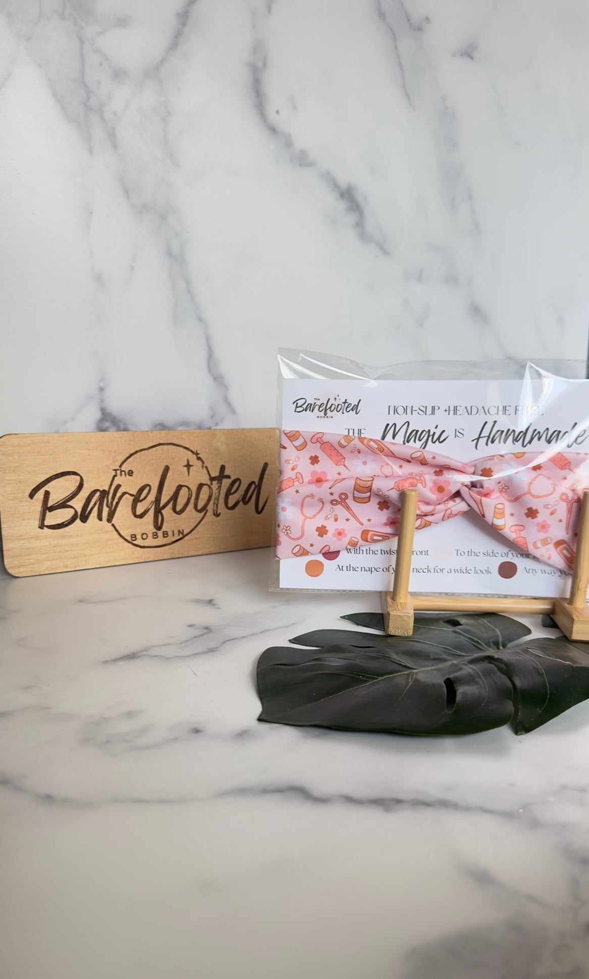 A pink headband with various medical supplies- bandaids, pill bottles, scissors, stethoscopes, thermometers as well as flowers